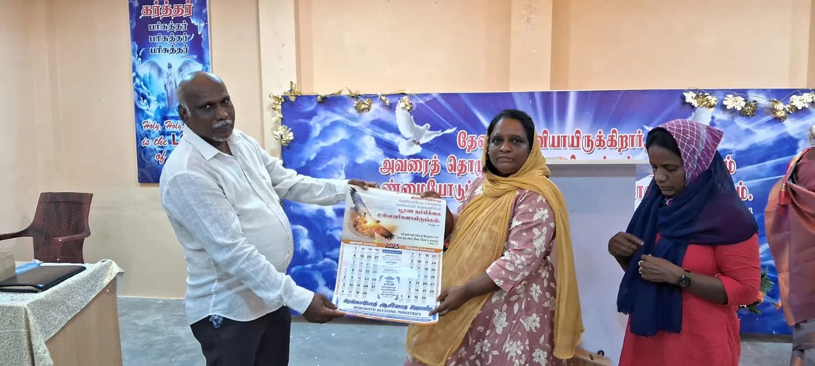 An adult participant receiving an item during an organisation-supplied community event
